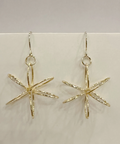 Gold star-shaped earrings on a light gray background