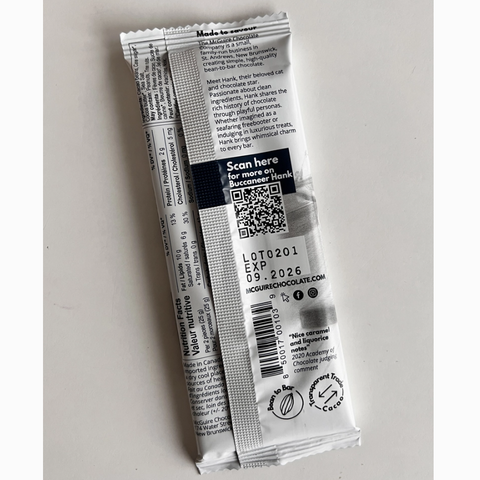 White and black product packaging with QR code on a light gray background