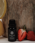 Black Sturgeon Moon essential oil bottle with lemons, strawberries, and a wooden block in the background