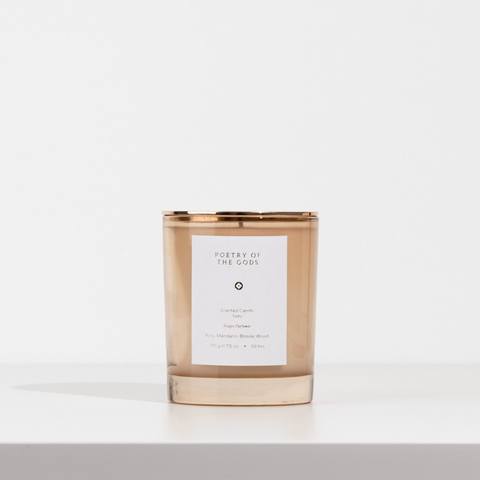 Candle with a gold lid and white label on a light gray background