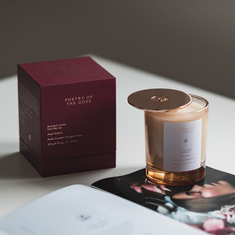 Candle with packaging and card on a light surface