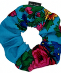 Colorful floral scrunchie with brand label on a white background