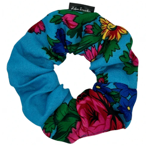Colorful floral scrunchie with brand label on a white background