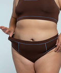 Brown thong with visible branding on a light gray background