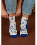 White socks with blue accents and cat designs worn by a person, displayed on a website page.