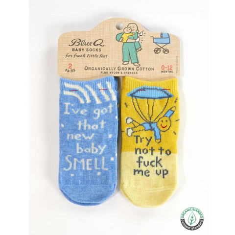 Pair of novelty baby socks with humorous text on a website page.