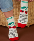 Sock with text and cherry design worn by a person, with product details on a website page.