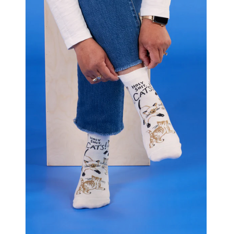 White socks with cat designs worn by a person on a blue background, with product details on the right side.