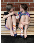 Two people sitting on a bench wearing colorful socks with text, with a product page overlay.