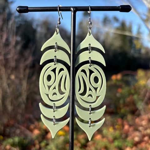 Pair of earrings on a stand with a blurred natural background