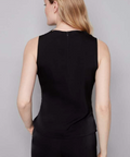 Woman wearing a black sleeveless top and black pants on a gray background