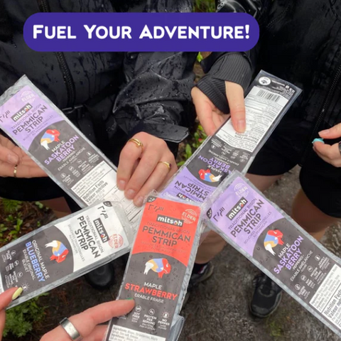 People holding packages of 'Mitsch' food strips with promotional text 'Fuel Your Adventure!'