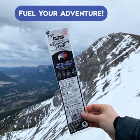 Hand holding a package of Mitsinjo berries with a mountainous landscape in the background and 'Fuel Your Adventure!' text.