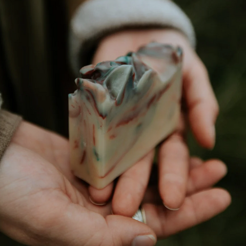Hand holding a piece of multicolored soap