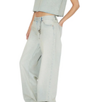 Person wearing light blue jeans and a matching top on a white background