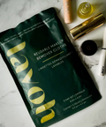 Reusable makeup remover cloths packaging on a marble surface with cosmetic items.