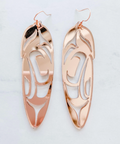 Rose gold earrings with intricate designs on a light gray background