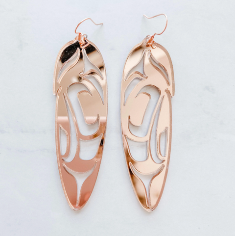 Rose gold earrings with intricate designs on a light gray background