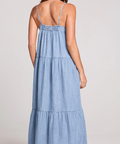 Woman wearing a blue denim dress on a plain background