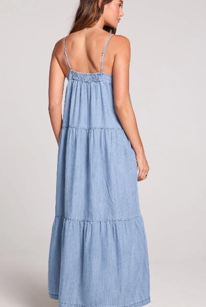 Woman wearing a blue denim dress on a plain background