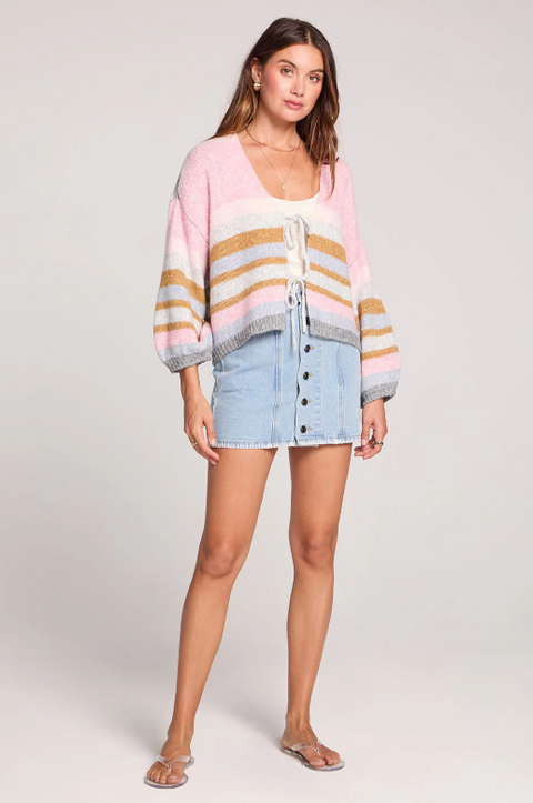 Woman wearing a striped cardigan and denim skirt on a white background