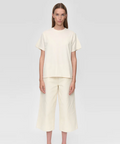 Person wearing a cream-colored outfit on a white background