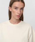 Woman wearing a plain beige t-shirt against a light gray background