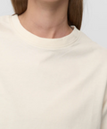 Close-up of a person wearing a beige sweater against a white background