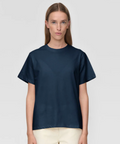 Woman wearing a navy blue t-shirt against a light gray background