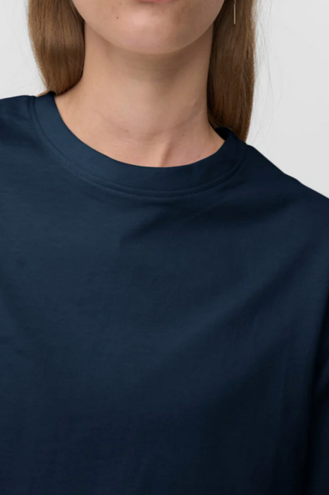 Navy blue t-shirt worn by a person on a white background