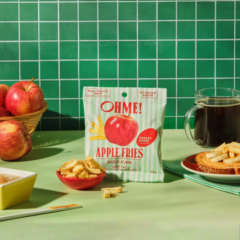 Packaged apple fries with apples and coffee on a green table