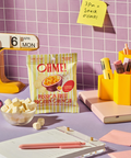 Protein crunch snack with office supplies on a desk against a tiled wall.