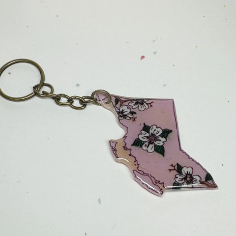 Keychain shaped like the state of British Columbia with floral design on a white background