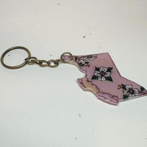 Keychain shaped like the state of British Columbia with floral design on a white background