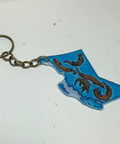 Keychain shaped like the outline of British Columbia with a dragon design on a white background