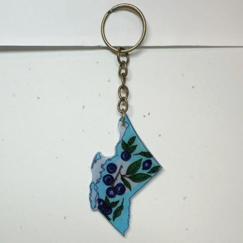 Keychain shaped like a stylized map of British Columbia with floral design on a white background