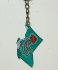 Keychain shaped like the state of British Columbia with a red flower design on a white background