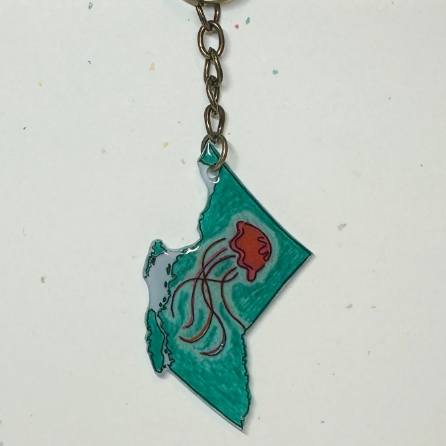 Keychain shaped like the state of British Columbia with a red flower design on a white background