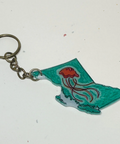 Keychain shaped like the state of British Columbia with a red flower on a white background