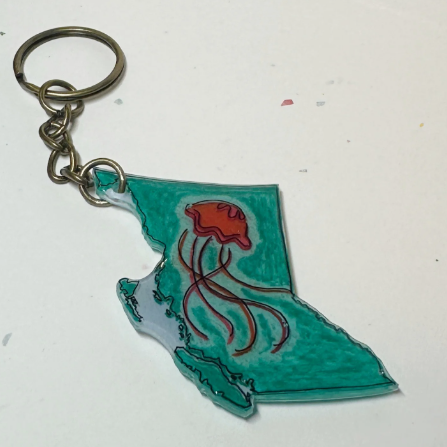 Keychain with a design of British Columbia and a jellyfish on a plain background