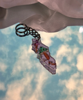 Keychain with a colorful pendant against a cloudy sky background