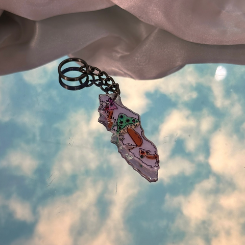 Keychain with a colorful pendant against a cloudy sky background