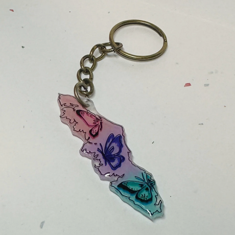 Keychain with butterfly design on a light gray background