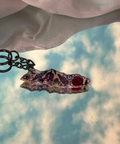 Decorative keychain with intricate designs on a fabric background
