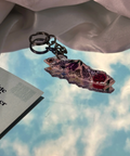 Decorative keychain on a surface with a magazine titled 'Tide and Timber' in the background.