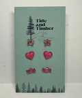 Set of earrings on a 'Tide and Timber' branded card with tree and wave design.