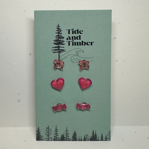 Set of earrings on a 'Tide and Timber' branded card with tree and wave design.