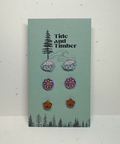 Earring set on a 'Tide and Timber' branded card with nature-themed design.