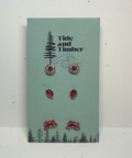 Set of earrings on a 'Tide and Timber' branded card with tree and flower designs.