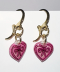 Pair of earrings with pink heart-shaped charms on a white background